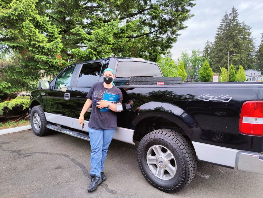 C standing next his new pickup truck, a large black truck with white trim.