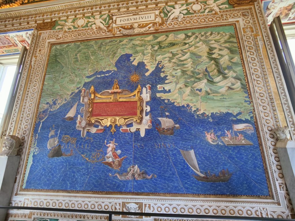 A large painted map of the northern Adriatic Sea. The water is decorated with three boats, a raft, and several monsters.